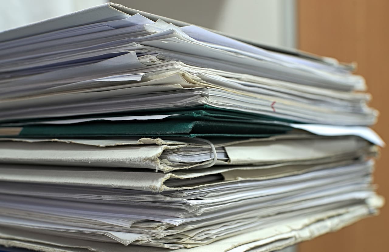 Pila de documentos y expedientes relacionados con la planificación de un proyecto ejecutivo.